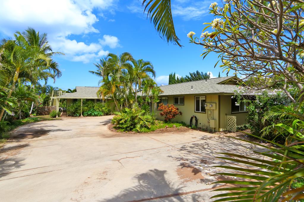 Home with large driveway and palm trees