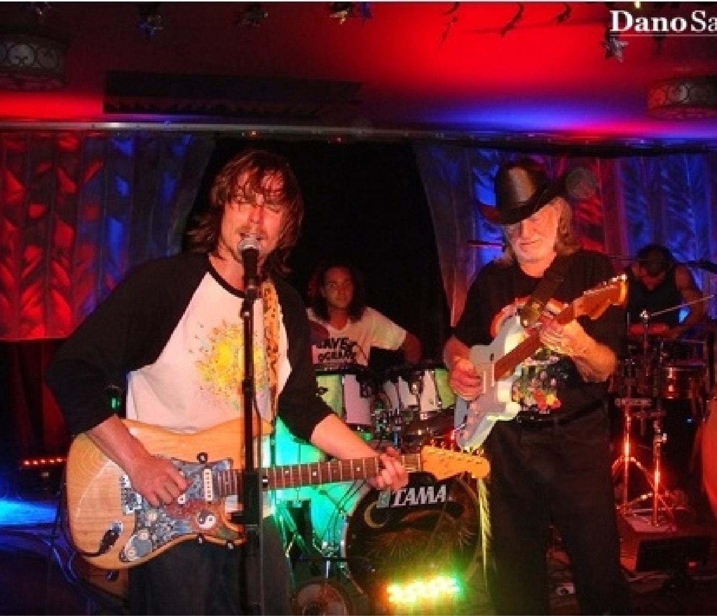 Willie Nelson playing a guitar while his son sings