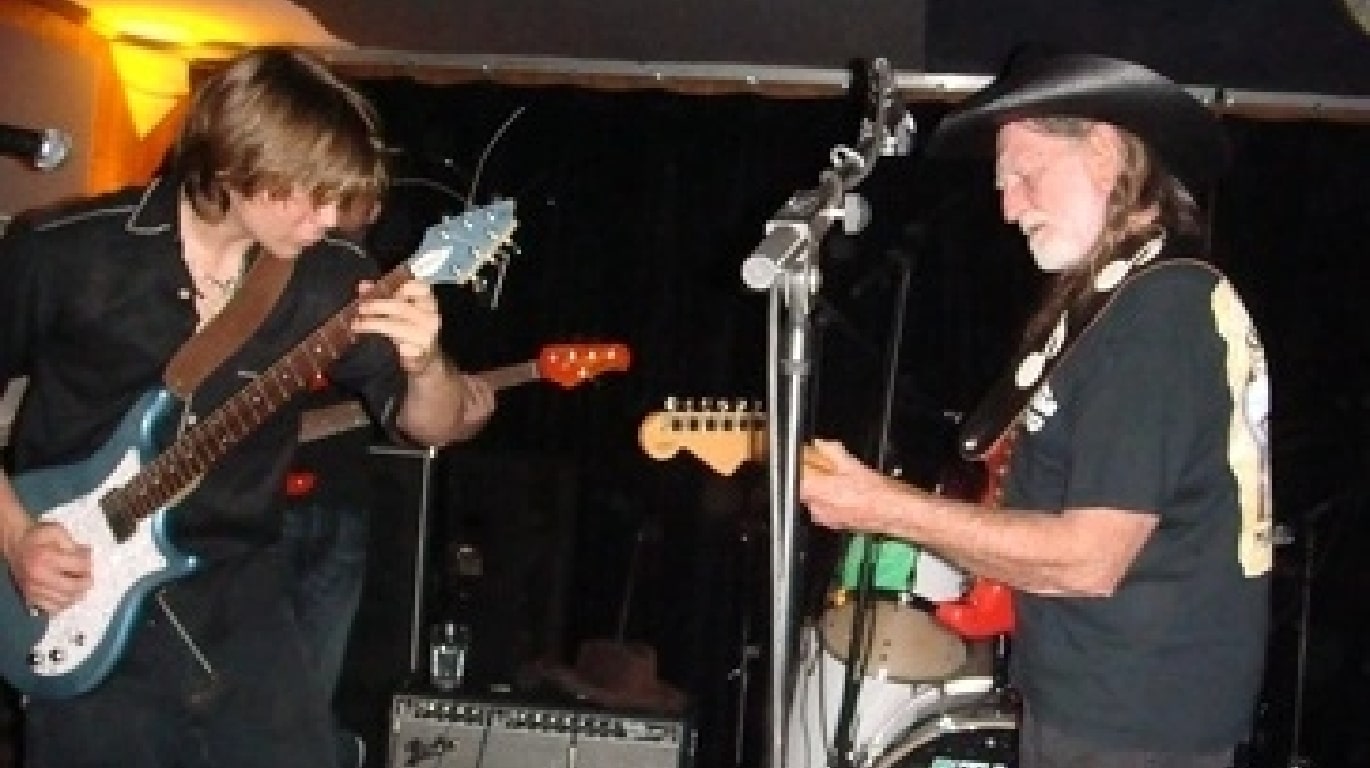 Willie Nelson playing guitar with his son